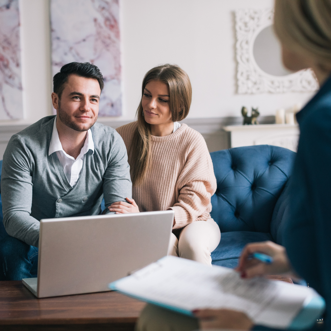 A young couple sitting in their living room speaking with one of our design matchmakers. Our in-home consultations are a great place to start your home remodeling journey.